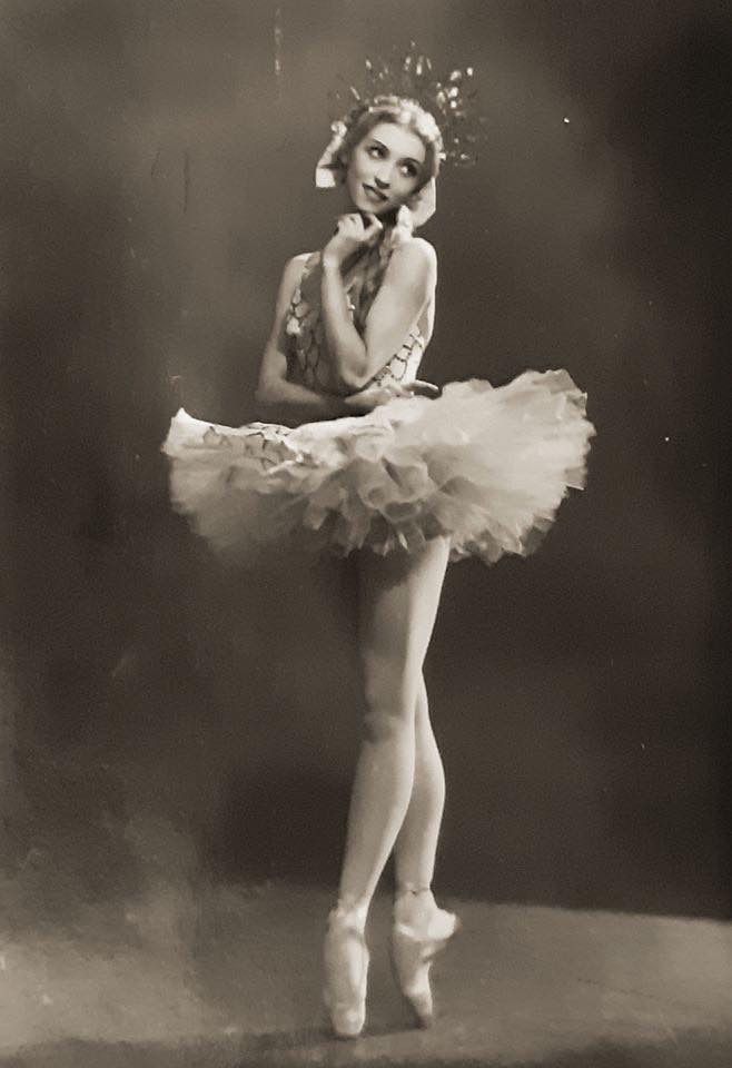 an old black and white photo of a ballerina in tutu with her arms behind her head