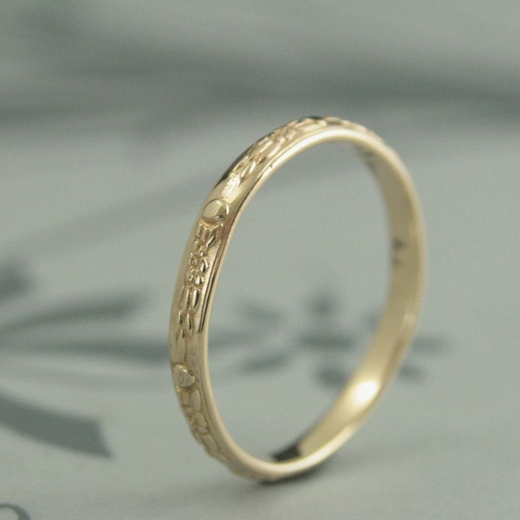 Like tiny waterlilies floating around your finger, our Monet band features a vintage style floral motif encircling the entire ring. Hand made in solid 14K yellow gold, this band measures 2.5mm wide by 1.3mm thick. This makes it a perfect sized wedding band that will last for generations. Your ring will be custom made to size just for you and given a meticulously hand polished finish. For this ring in 14K white gold: https://www.etsy.com/listing/466475336 Classic 14k Stamped Wedding Ring, Yellow Gold Wedding Ring With Round Band, 14k Yellow Gold Engraved Wedding Ring, Heirloom Wedding Ring With Round Band, Wedding Ring With Round Decorative Band, Stamped 14k Band Jewelry For Wedding, Stamped 14k Wedding Band, Engraved Round Cut Ring Stamped 14k For Wedding, Engraved 14k Wedding Ring