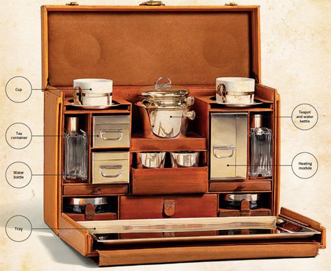 an open wooden box with cups and saucers in it