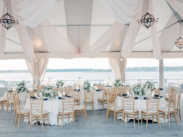 the tables are set with white linens and blue centerpieces for an elegant wedding reception