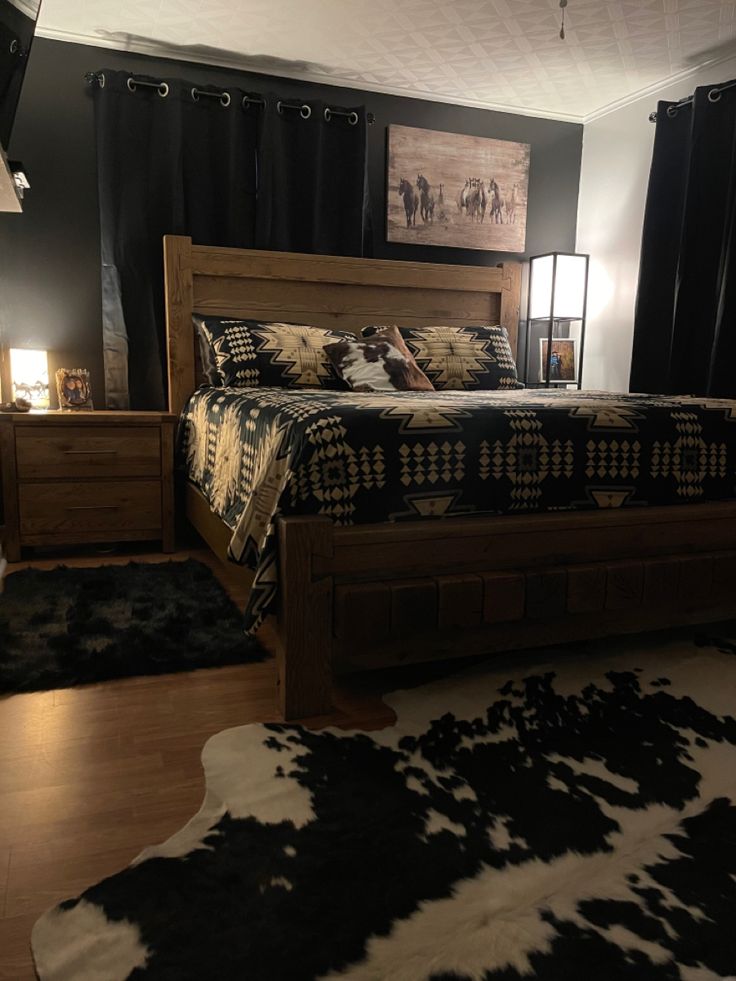 a bedroom with black and white cowhide rugs on the floor, bed in center