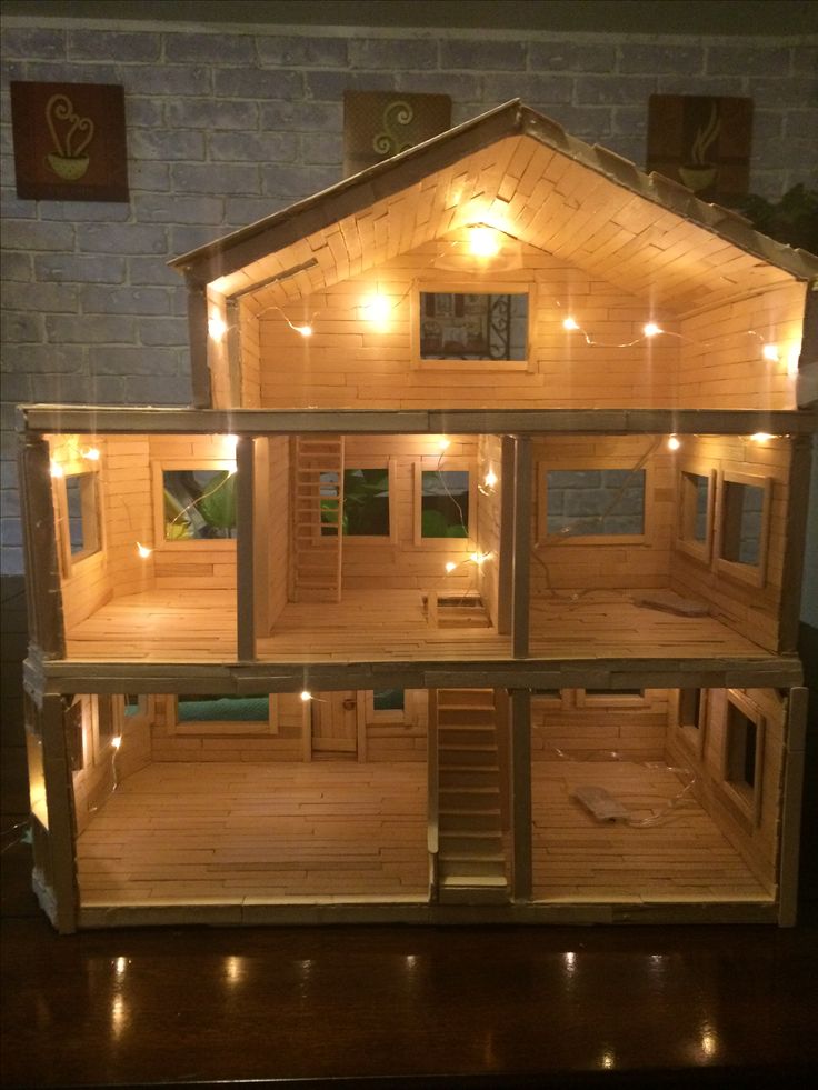 a wooden doll house with lights on it