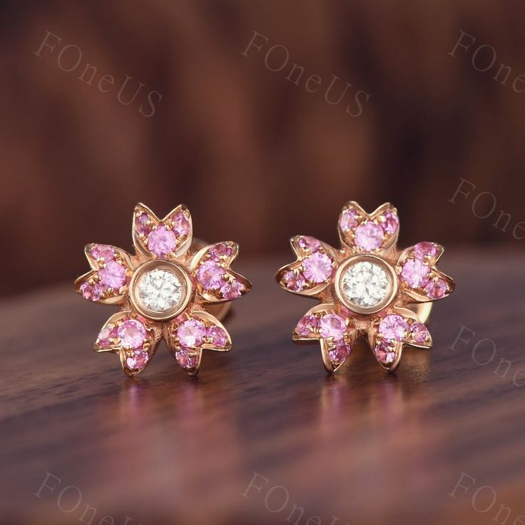 These flower style pink sapphire earrings shine with luminous elegance. They are sophisticated and chic. These tiny gold and gemstone earrings will be perfect addition to your stunning look and will make your beauty shine! Details Gemstone: Natural Pink Sapphire Middle stone: 2.5mm round cut Moissanite Each set comes with 2 post back earrings ◇◇Processing time◇◇ Any item on my store is handmade,made to order,no stock. Typically,it takes 2-3 weeks to complete the item. ◇◇Delivery time◇◇ --Domesti Pink Diamond Earrings With Prong Setting For Wedding, Pink Gemstone Earrings In Flower Shape, Pink Gemstone Earrings With Flower Shape, Pink Gemstone Flower-shaped Earrings, Wedding Pink Sapphire Earrings, Pink Diamond Gemstone Earrings For Anniversary, Pink Earrings With Halo Design Fine Jewelry, Fine Jewelry Pink Earrings With Halo Design, Pink Round Diamond Earrings For Wedding