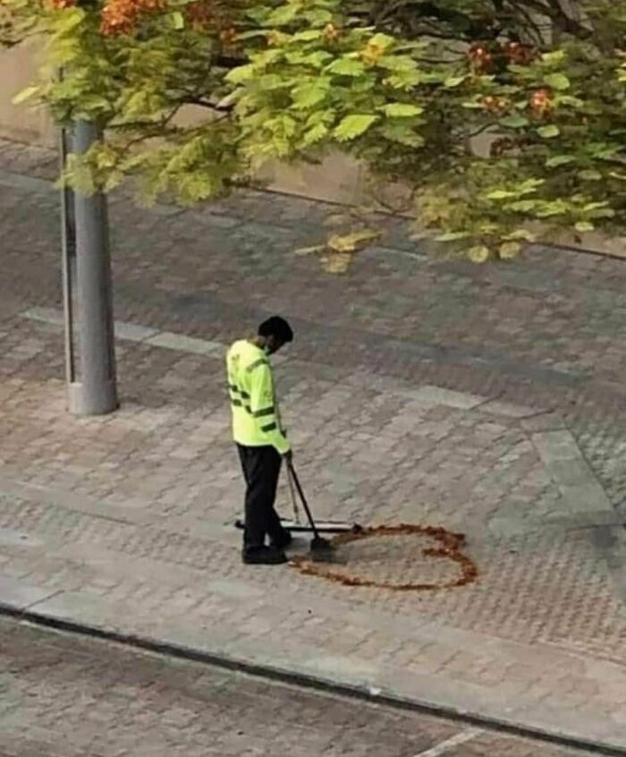 a man with a mop is standing on the sidewalk