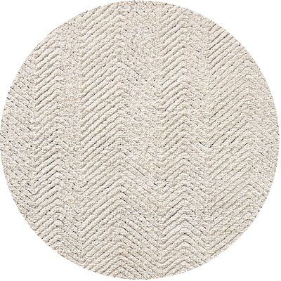 a round rug with white chevrons on the bottom, and an oval pattern in the middle