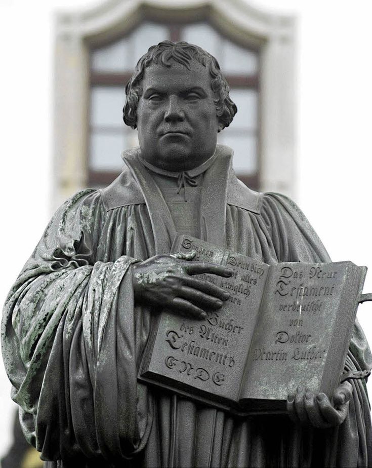 a statue of a man holding a book in his hands