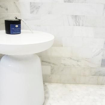 a white pedestal sink sitting in a bathroom next to a tiled wall and counter top