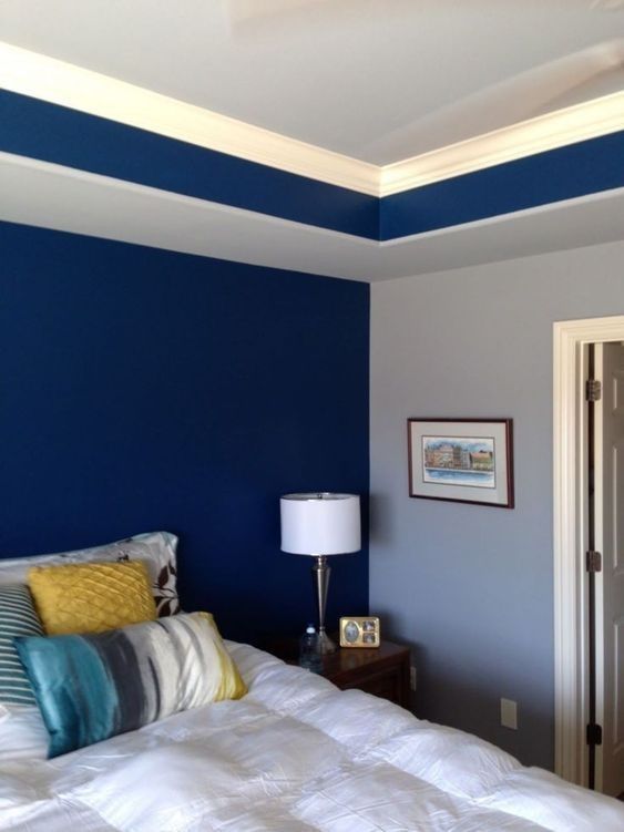 a bedroom with blue walls and white bedding