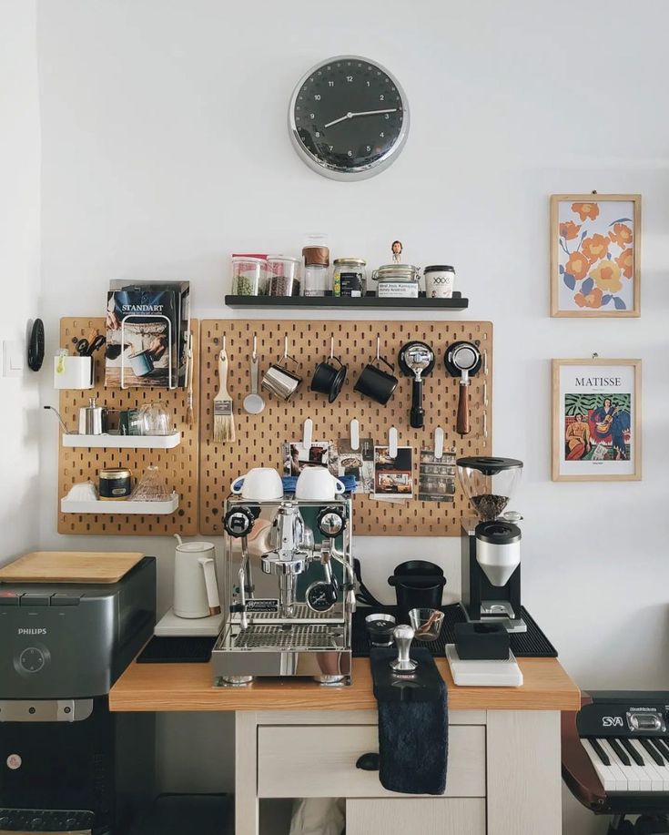 a coffee machine sitting on top of a wooden table next to a wall mounted clock