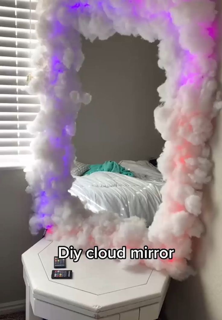 a room with a bed and clouds on the wall, in front of a window that says diy cloud mirror