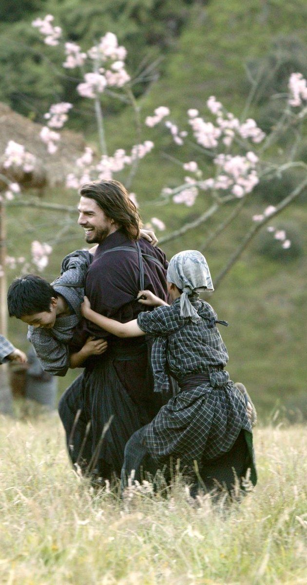 a group of people walking across a grass covered field