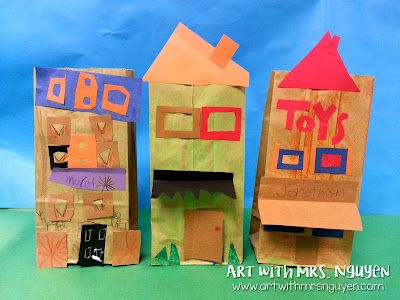 three paper bags with houses on them sitting next to each other in front of a blue background