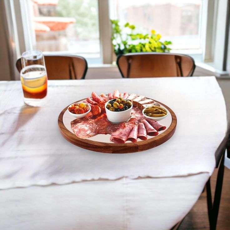 a wooden plate topped with meats and sauces on top of a white table