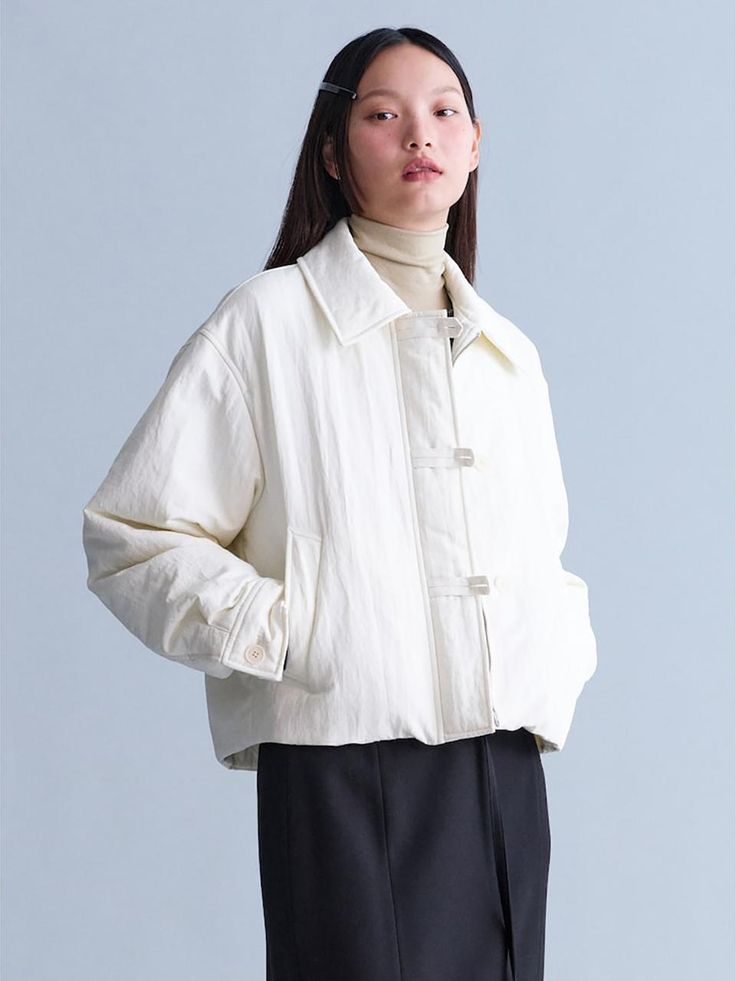 This padded jacket offers a sleek, minimalistic design with a standout closure detail. It boasts a voluminous silhouette that can be adjusted using the hem strings, creating a personalized fit.- Appropriate length allowing for versatile looks- Oversized fit for comfortable wear experience- Lightweight nylon blend with 3M Thinsulate insulation White Padded Collar Outerwear For Work, White Outerwear With Padded Collar For Work, Spring Workwear Quilted Jacket With Padded Collar, Modern Spring Outerwear With Padded Collar, Modern Outerwear With Padded Collar, Modern Long Sleeve Outerwear With Padded Collar, Oversized Puffer Jacket With Pockets For Work, Puffer Parka, Minimalistic Design