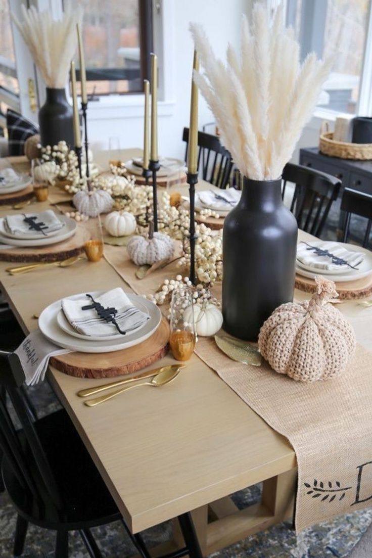 a table set for thanksgiving dinner with black and white decor