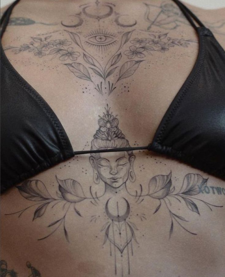 the back of a woman with tattoos on her chest and lower back, in black leather