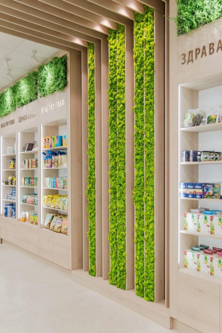 the inside of a store with green plants growing on the wall and shelves full of food