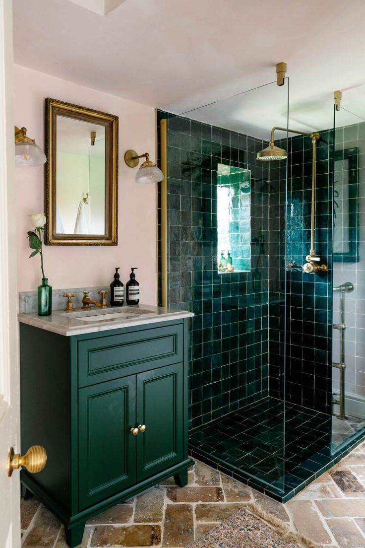 a bathroom with a green cabinet, sink and shower stall in the middle of it