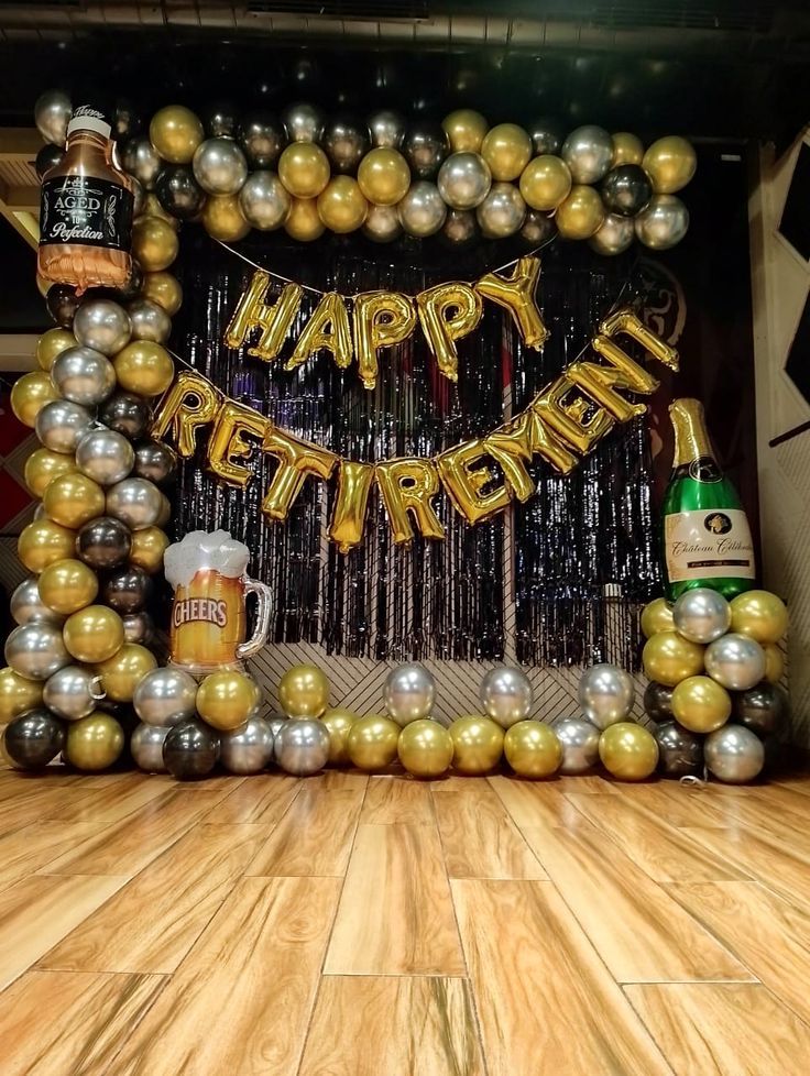 a happy retirement balloon arch with beer mugs and balloons on the floor in front of it