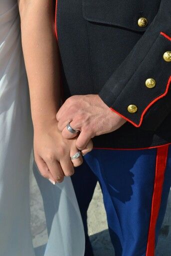 a man and woman holding hands while standing next to each other