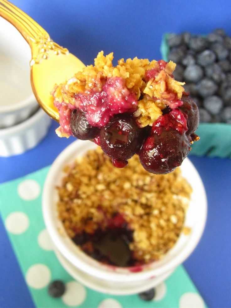 a spoon full of blueberries and granola