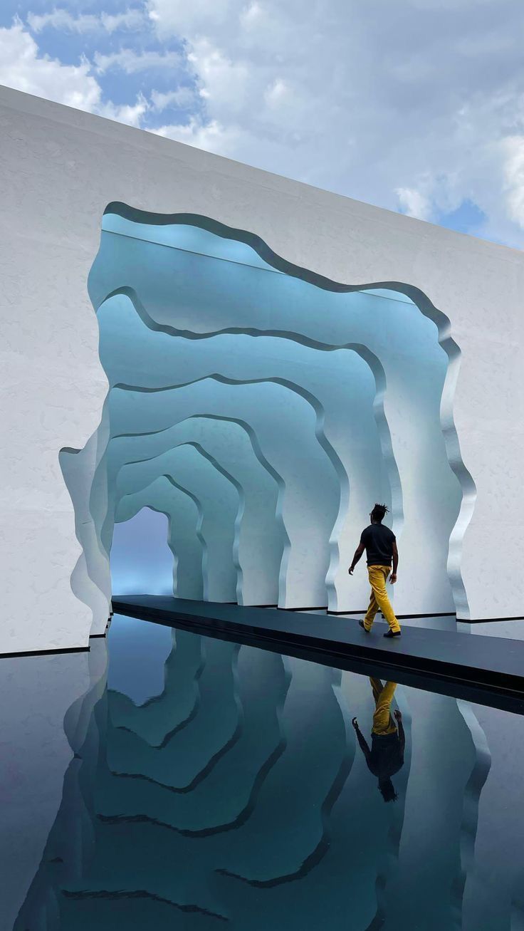 a man is walking in front of an iceberg that looks like it's melting