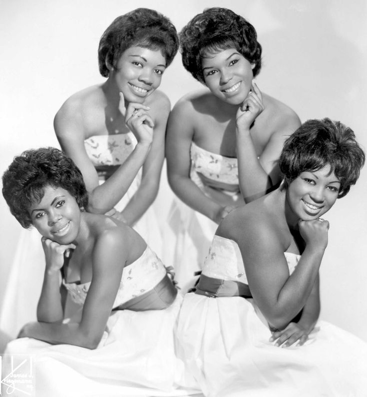 four women in bathing suits are posing for a photo together with their hands on their chins