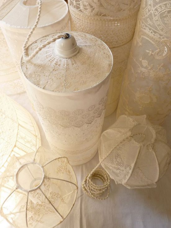 several white lace covered jars and doily on a tableclothed surface with an umbrella in the center