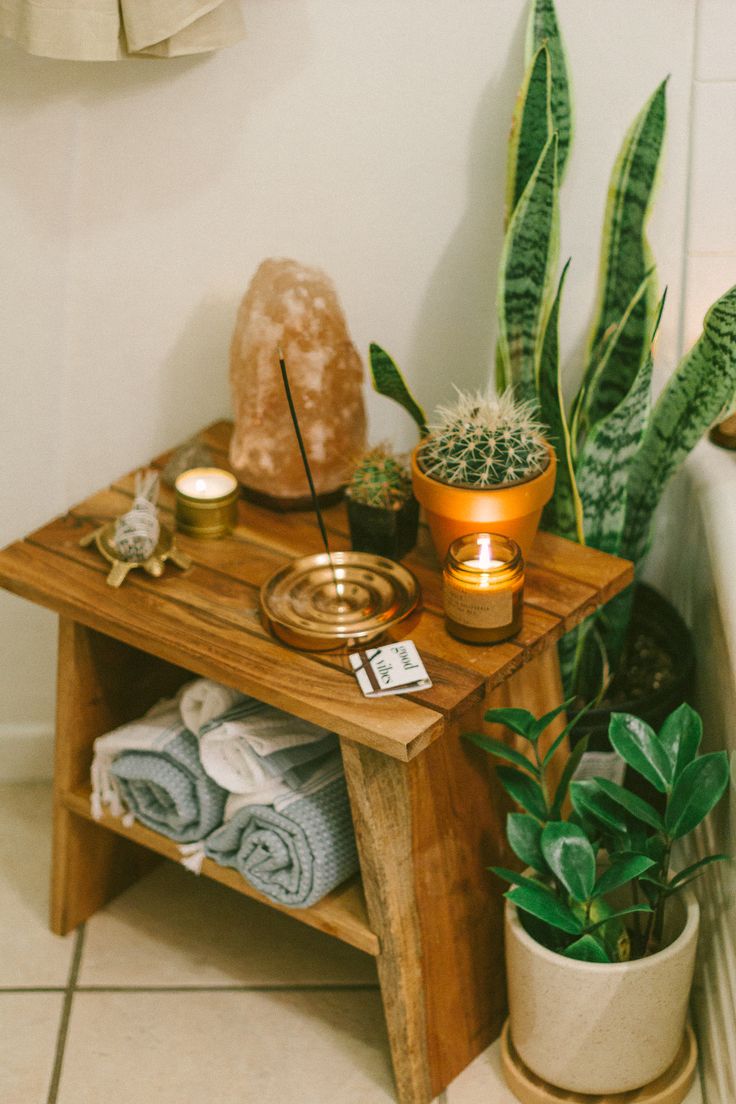 a wooden table topped with potted plants and candles