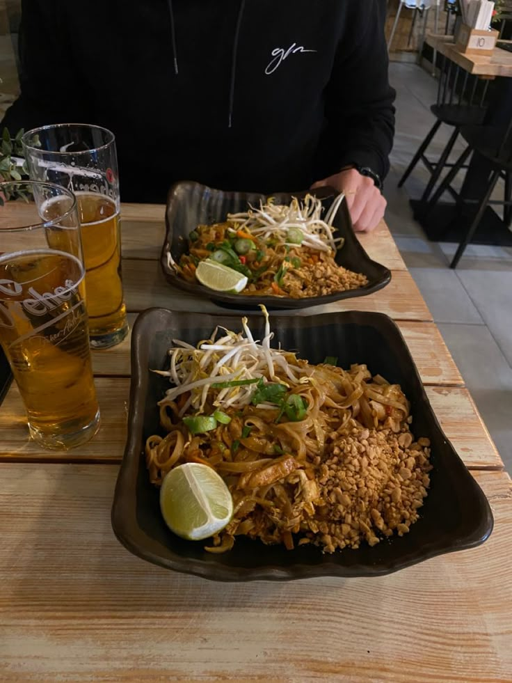 a man sitting at a table with two plates of food