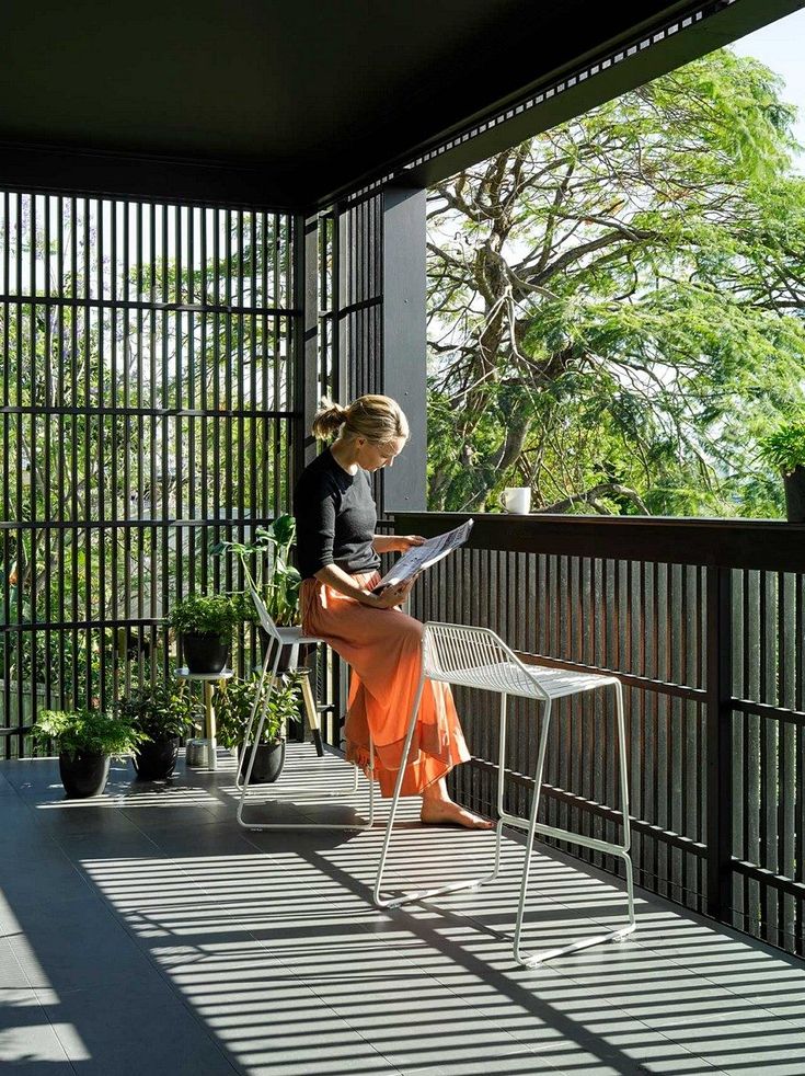 a woman sitting at a table on top of a balcony