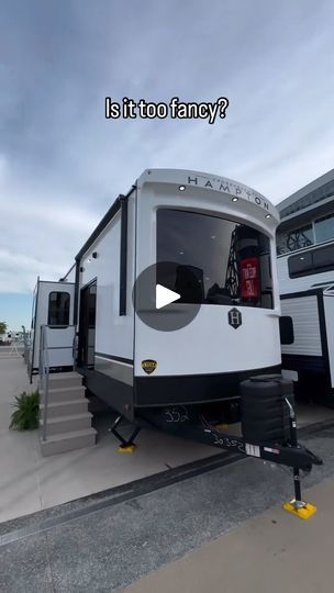 an rv is parked in front of another trailer with stairs leading up to the door