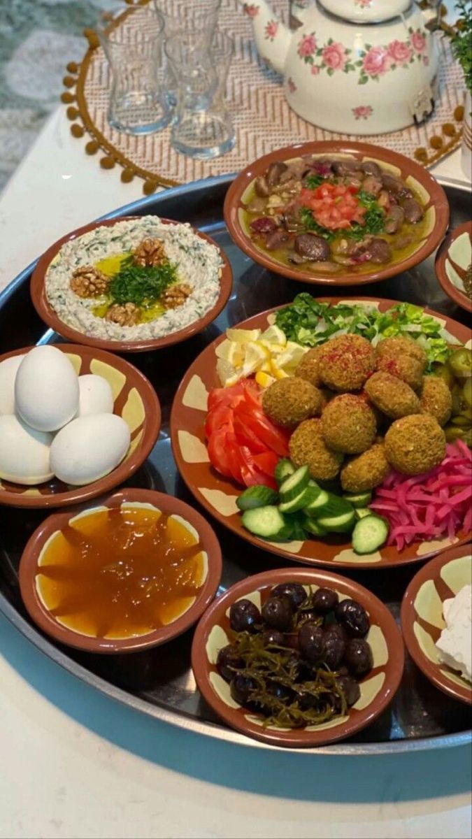 an assortment of food is displayed on a platter with sauces and condiments