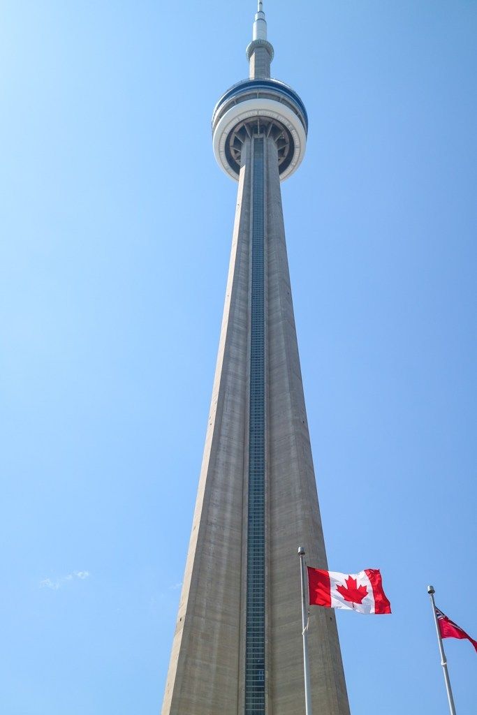 the canadian flag is flying in front of the tower