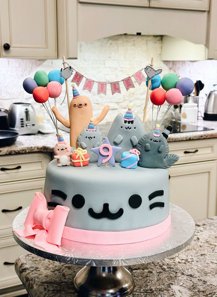 a cake decorated with cats and balloons on a countertop in a home kitchen area