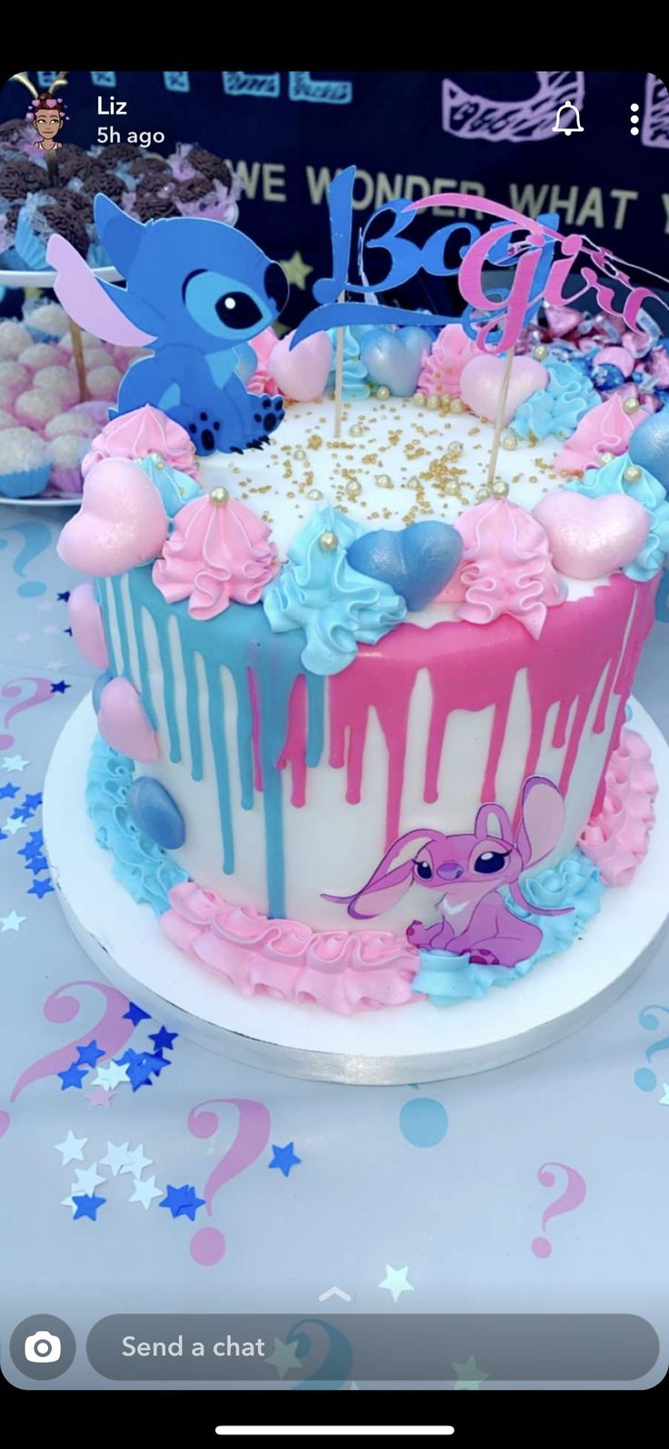 a birthday cake with pink and blue icing on it, sitting on top of a table