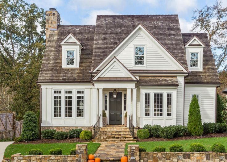 a house with white siding and brown shingles