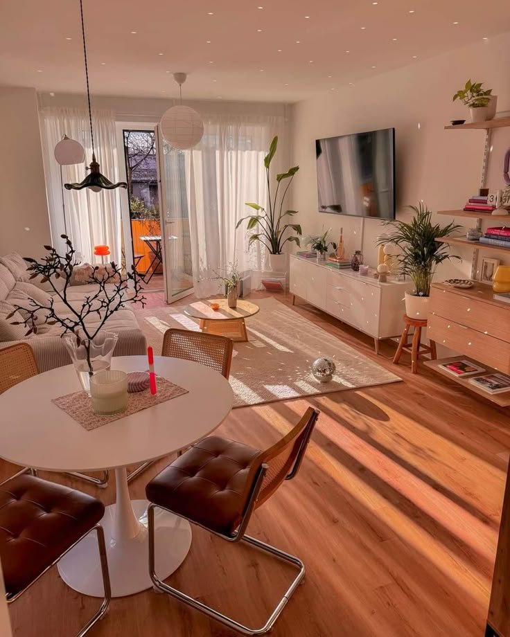 a living room filled with furniture and a flat screen tv on top of a wooden floor