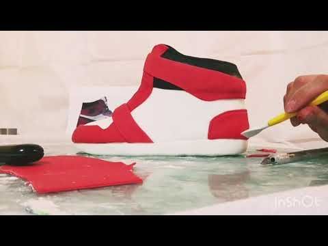 someone is painting a pair of red and white sneakers with yellow markeres on the table