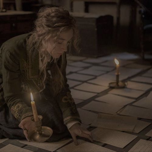 a woman kneeling on the floor in front of two candles