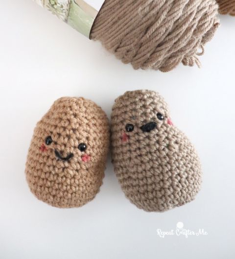 two crocheted stuffed animals sitting next to each other on top of a table