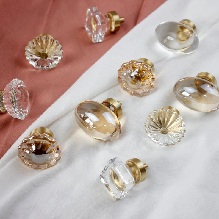 an assortment of glass knobs on a white cloth