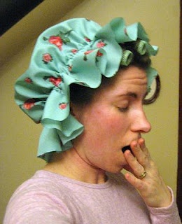 a woman in a pink shirt is brushing her teeth and wearing a blue flowered hair bow