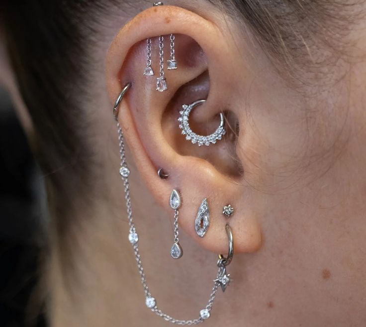 a woman's ear is adorned with silver jewelry