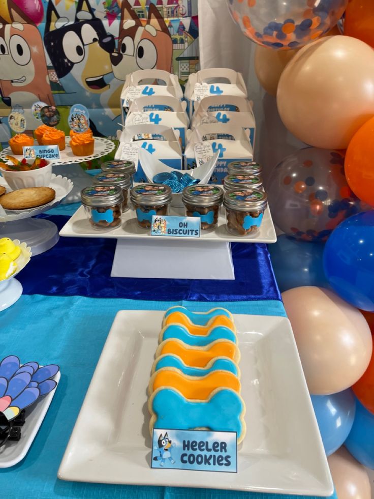 a table topped with lots of desserts and balloons