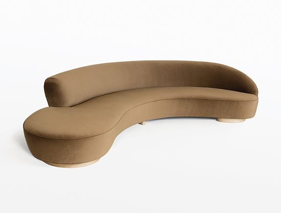 a curved couch sitting on top of a white floor