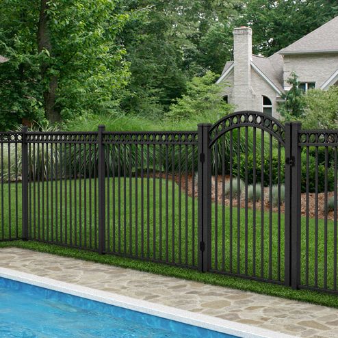 a pool with a fence surrounding it and a house in the background