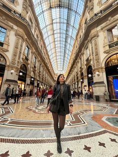 a woman standing in the middle of a shopping mall