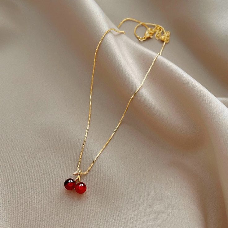 Enhance any outfit with this beautiful Wine Red Cherry Gold Pendant Necklace. Featuring a classic design and bold red hues, it will make a stunning fashion statement that will be admired by all. This statement piece is perfect for your collection. Red Ruby Round Necklaces, Elegant Cherry Colored Jewelry For Party, Red Round Necklace For Her, Red Round Jewelry, Red Clavicle Chain Necklace For Party, Elegant Red Necklace With Clavicle Chain, Red Ruby Jewelry Gift For Her, Elegant Red Clavicle Chain Jewelry, Elegant Red Clavicle Chain Necklace