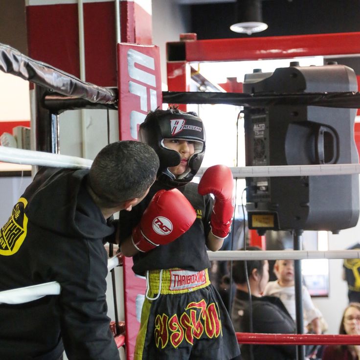 two young men in boxing gloves standing next to each other